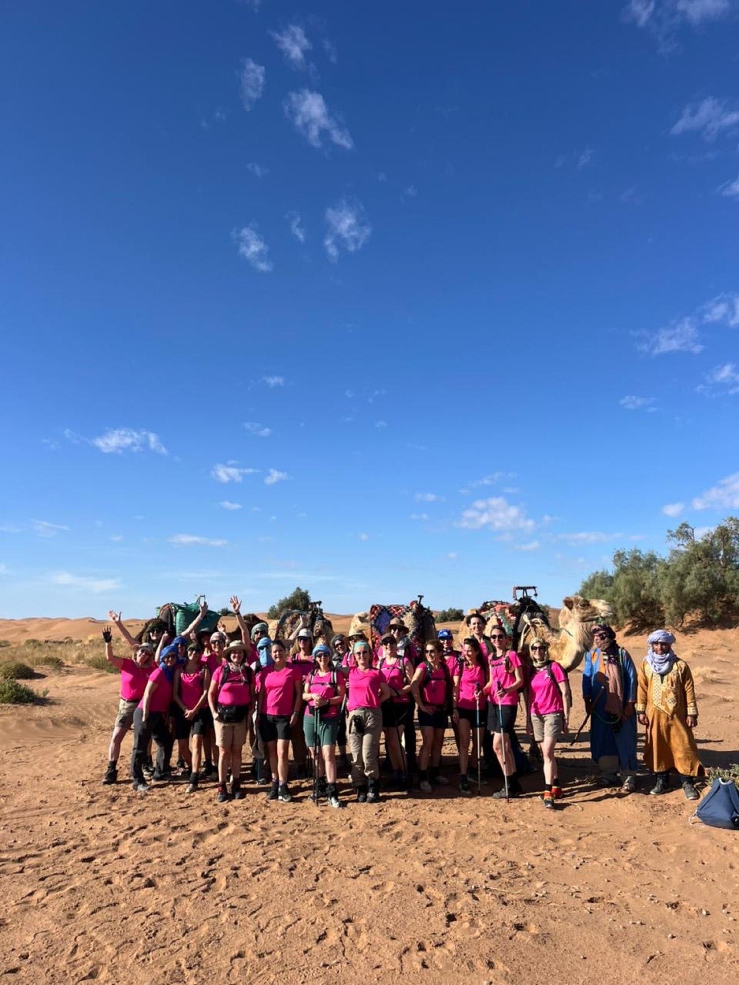 Groupe de trekkeuses posant avec les dromadaires dans l'Erg Chegaga