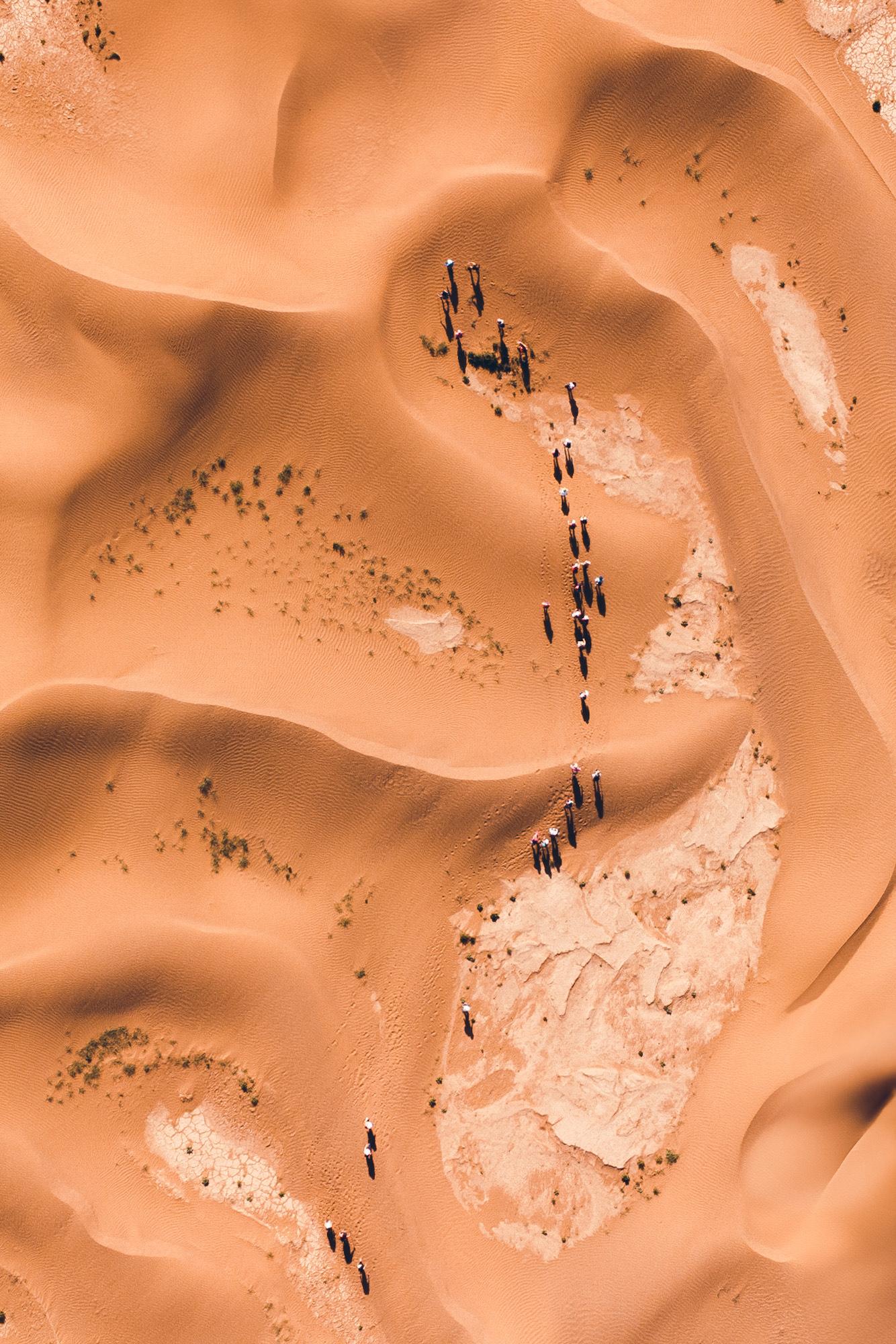 Trekkeuse marchant seule dans les dunes à la lumière chaude du soir